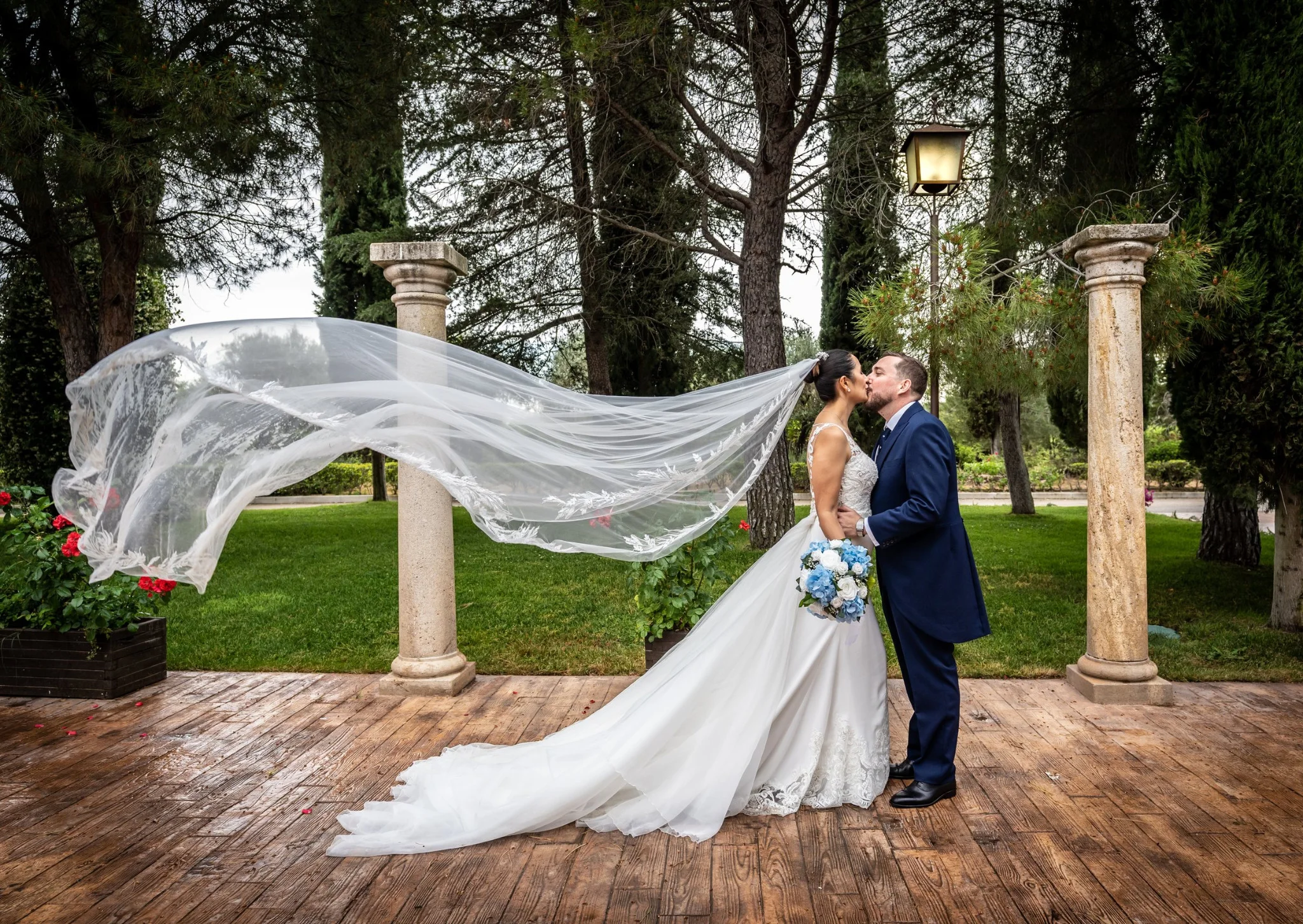 Beso de los novios con el velo movido por el viento en una boda en Peñarrubia de Araceli, fotografía de Pedro Zamorano.