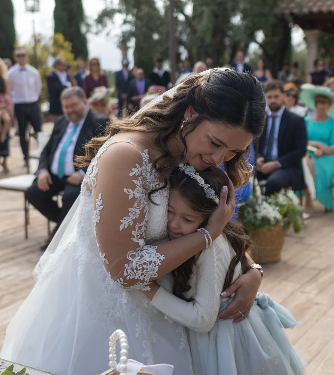 Novia abrazando a una niña durante la ceremonia en una boda en Peñarrubia de Araceli, fotografía de Pedro Zamorano.