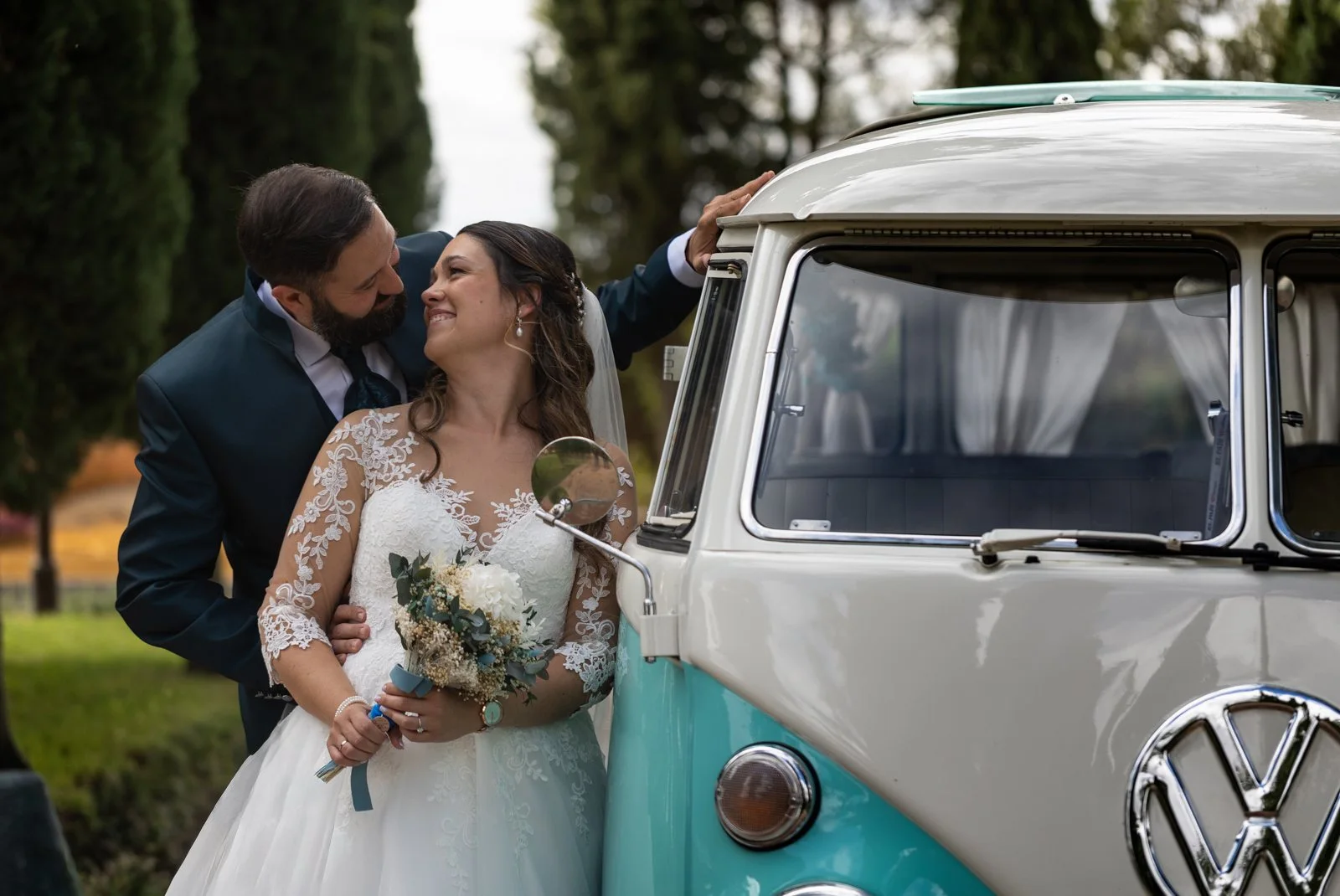 Novios besándose junto a una furgoneta Volkswagen clásica en una boda en Peñarrubia de Araceli, fotografía de Pedro Zamorano.