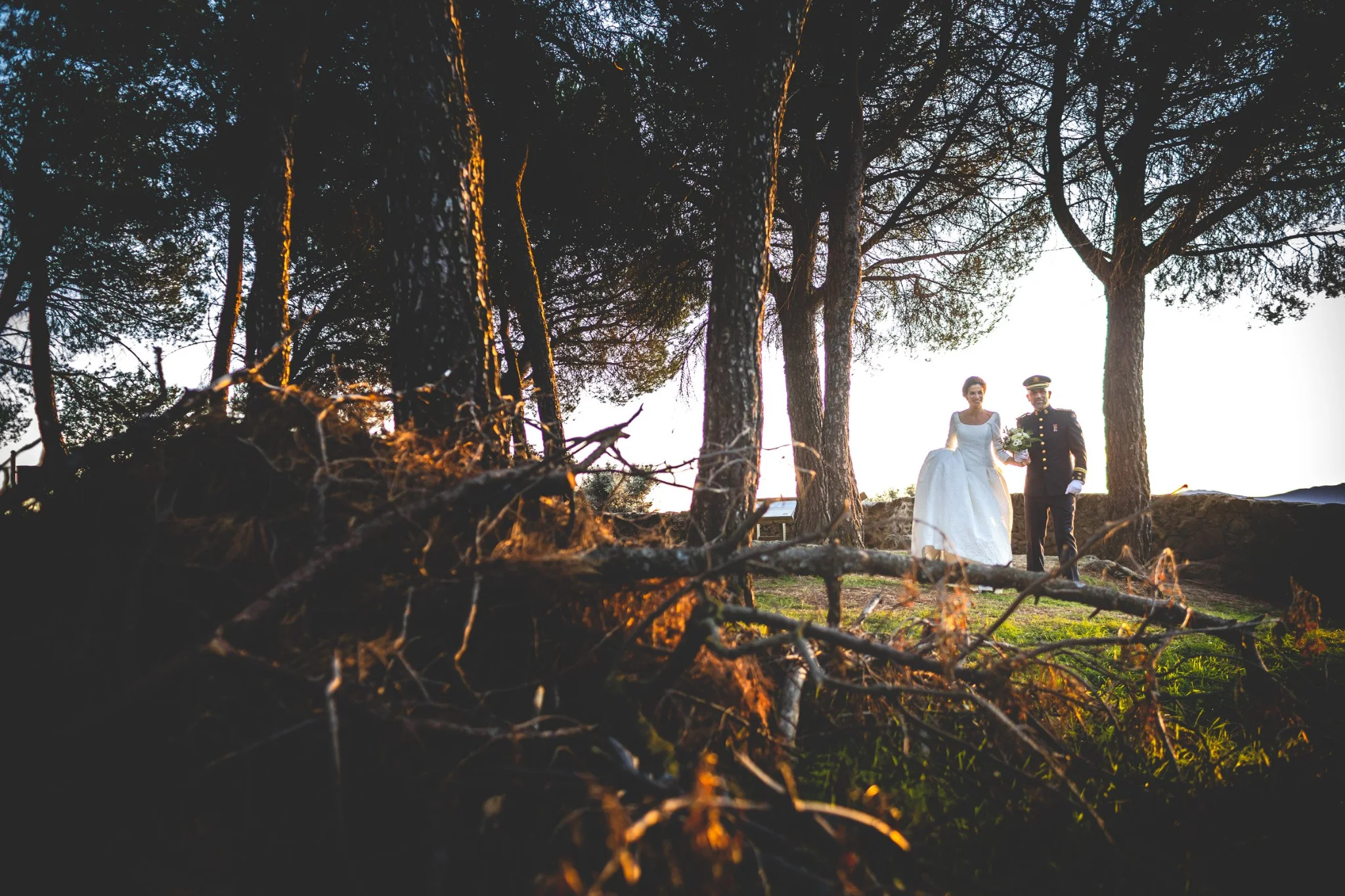 Novios retratados entre árboles a contraluz en una boda en Peñarrubia de Araceli, fotografía de Pedro Zamorano.