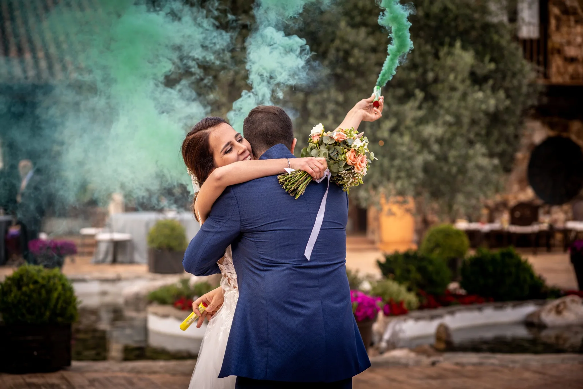 Abrazo de los novios con bengala de humo verde en una boda en Peñarrubia de Araceli, fotografía de Pedro Zamorano.