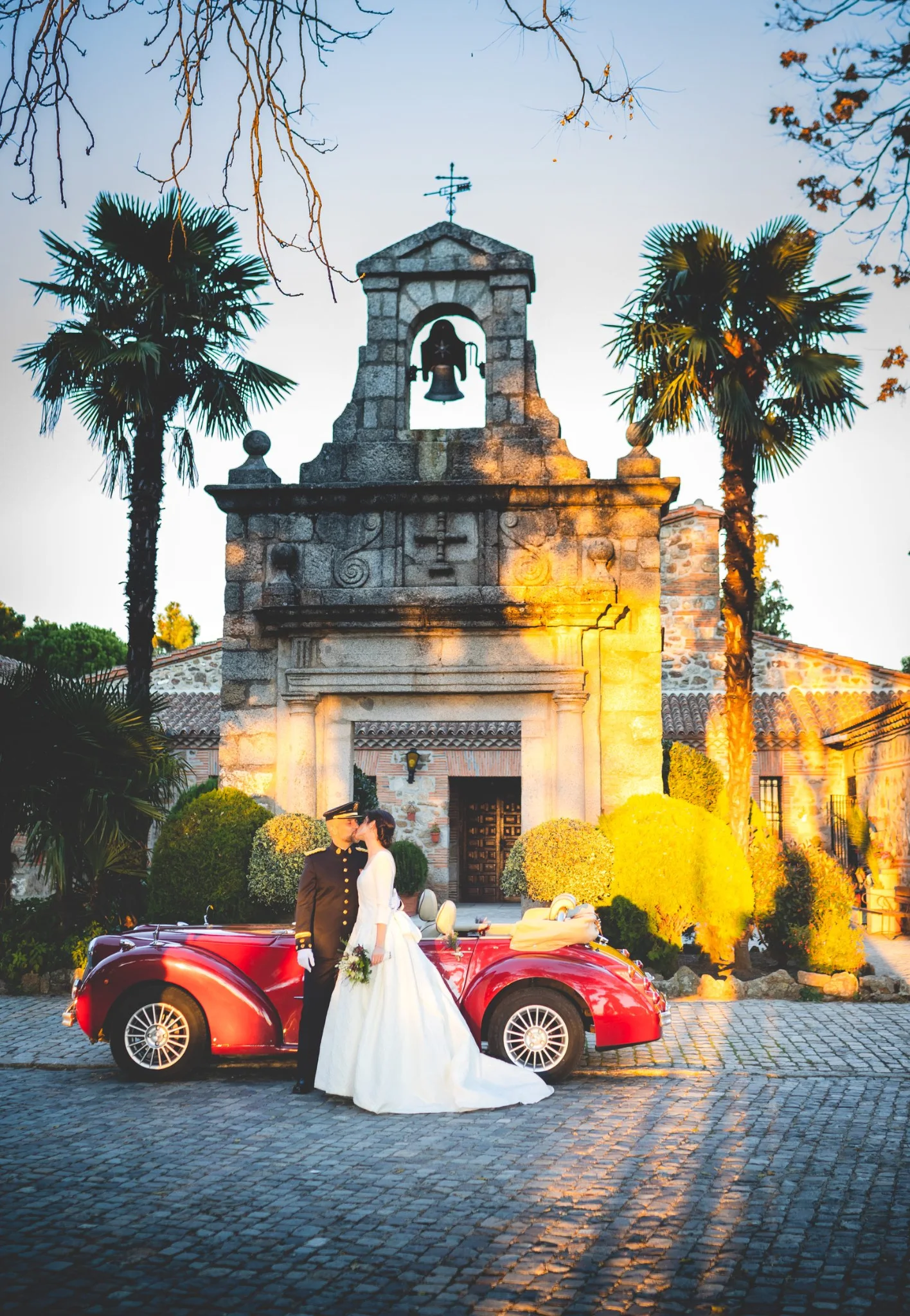 Novios junto al coche clásico frente a la capilla en una boda en Peñarrubia de Araceli, fotografía de Pedro Zamorano.