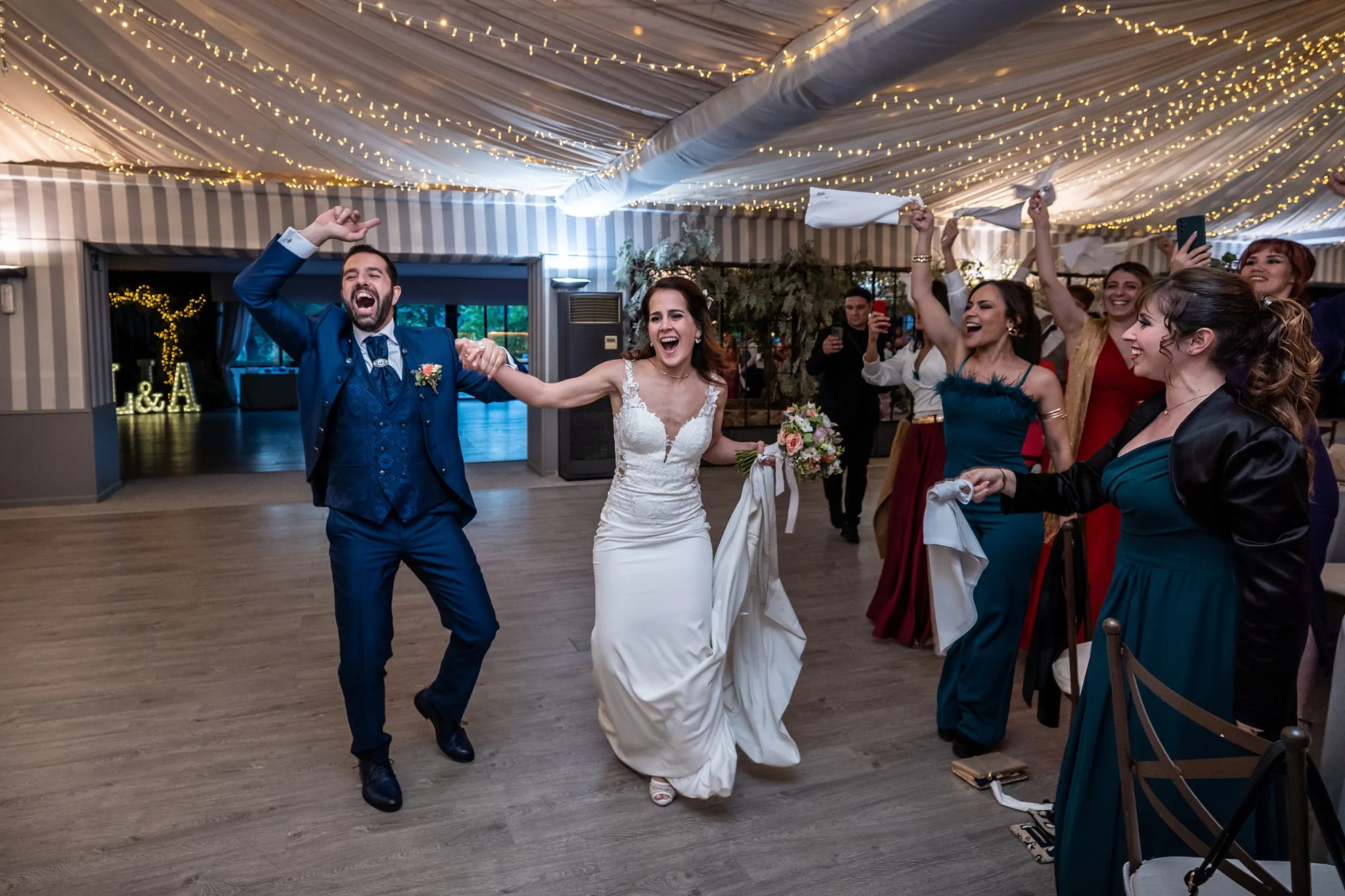 Entrada alegre de los novios acompañados por invitados en una boda en Peñarrubia de Araceli, fotografía de Pedro Zamorano.