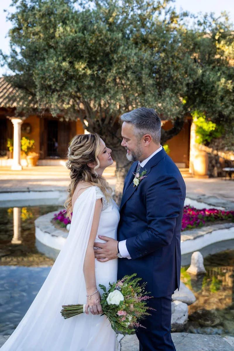 Retrato vertical de los novios en el jardín en una boda en Peñarrubia de Araceli, fotografía de Pedro Zamorano.