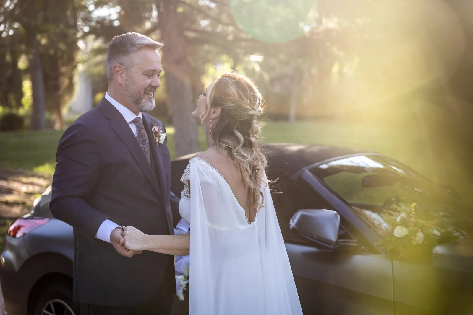 Novios conversando junto al coche antes del paseo en una boda en Peñarrubia de Araceli, fotografía de Pedro Zamorano.