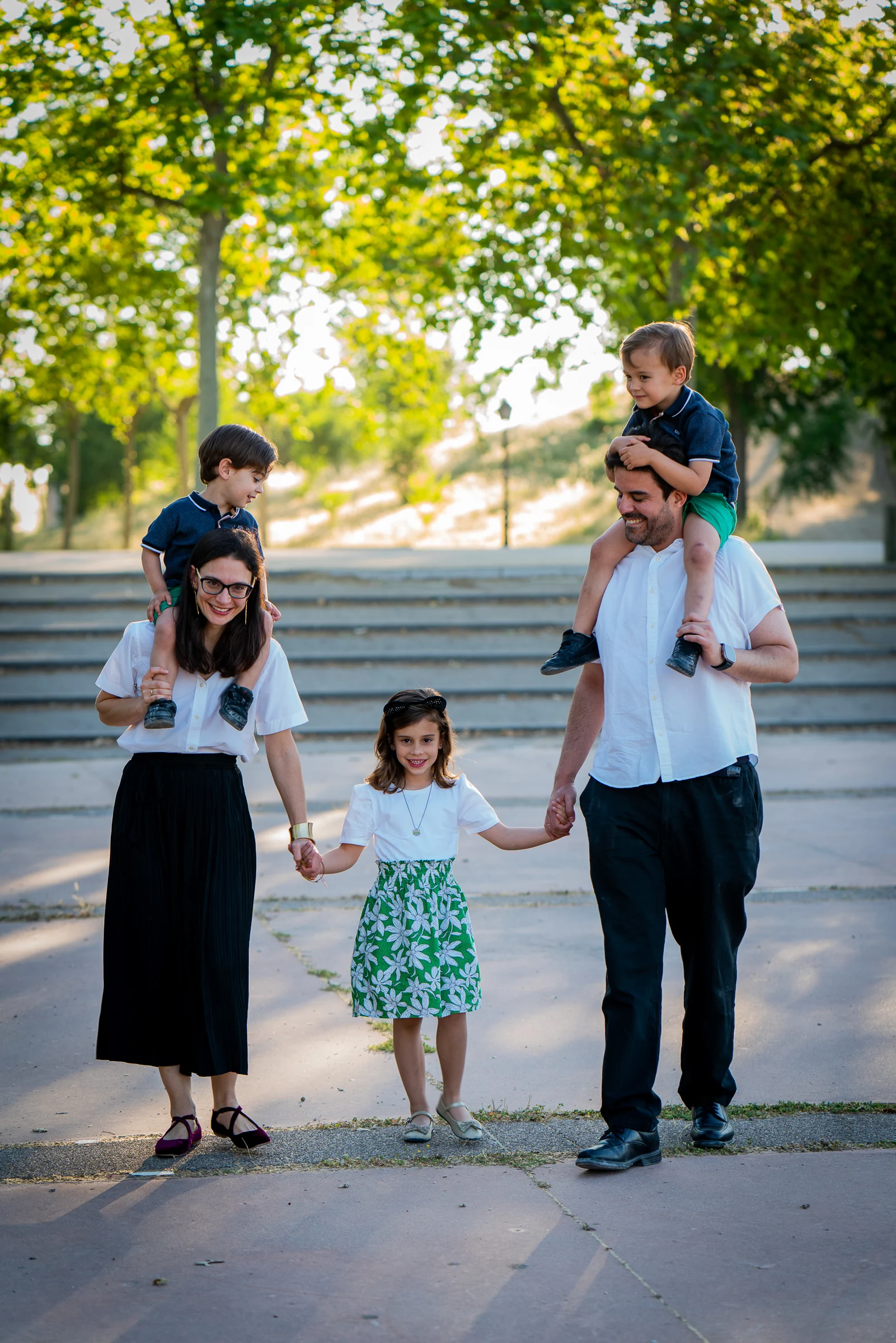 Familia de cinco personas posa junta al aire libre durante una sesión familiar.