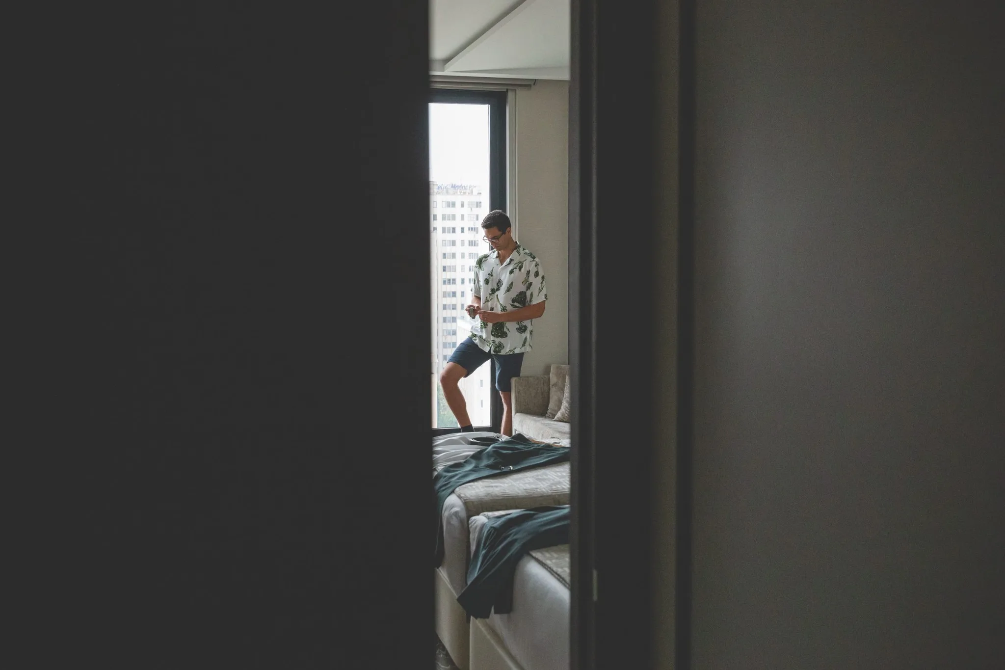Novio preparandose junto a la ventana durante una boda en Valquijancho.