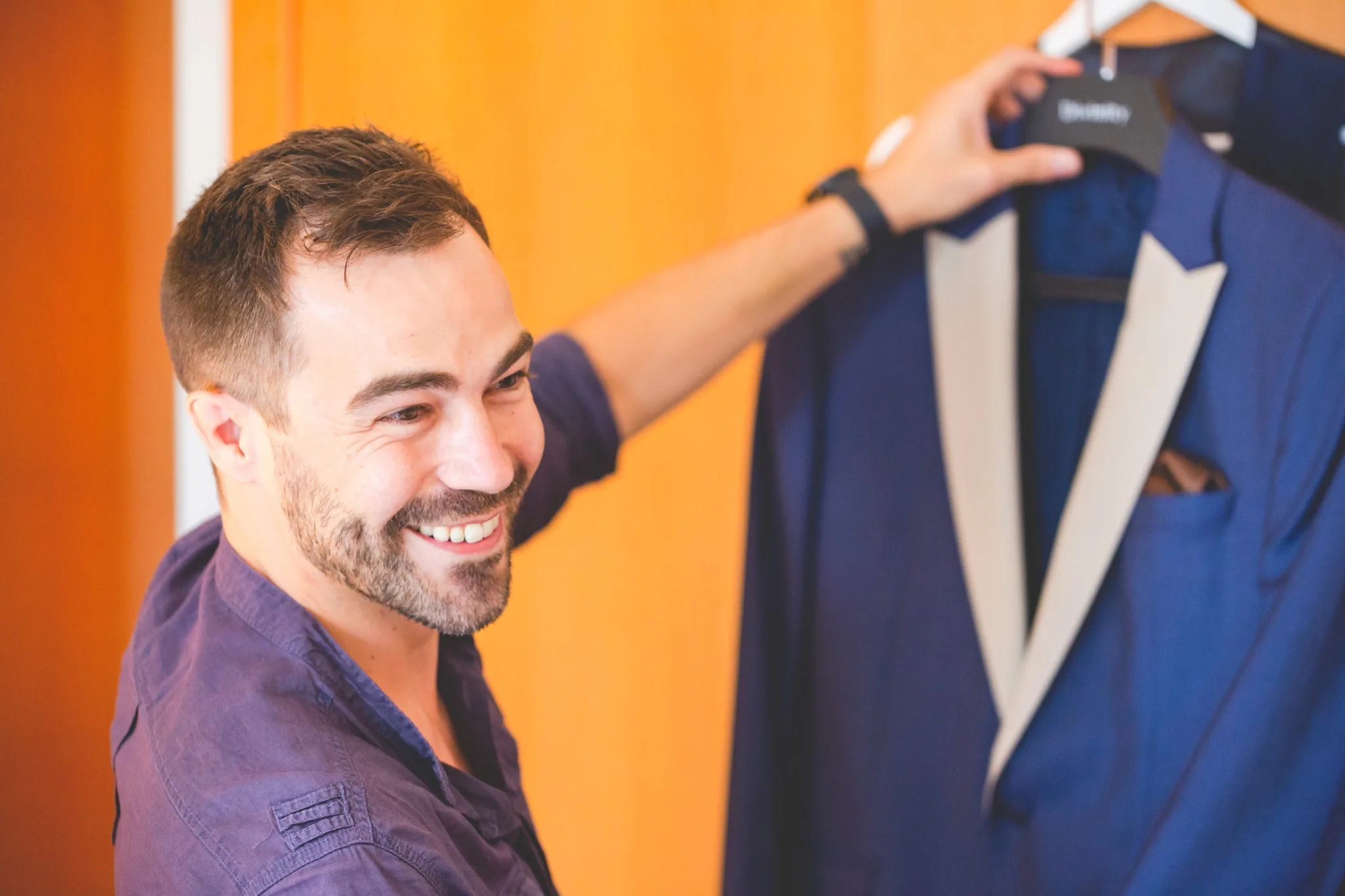 Novio sonriente junto a su traje durante una boda en Valquijancho.