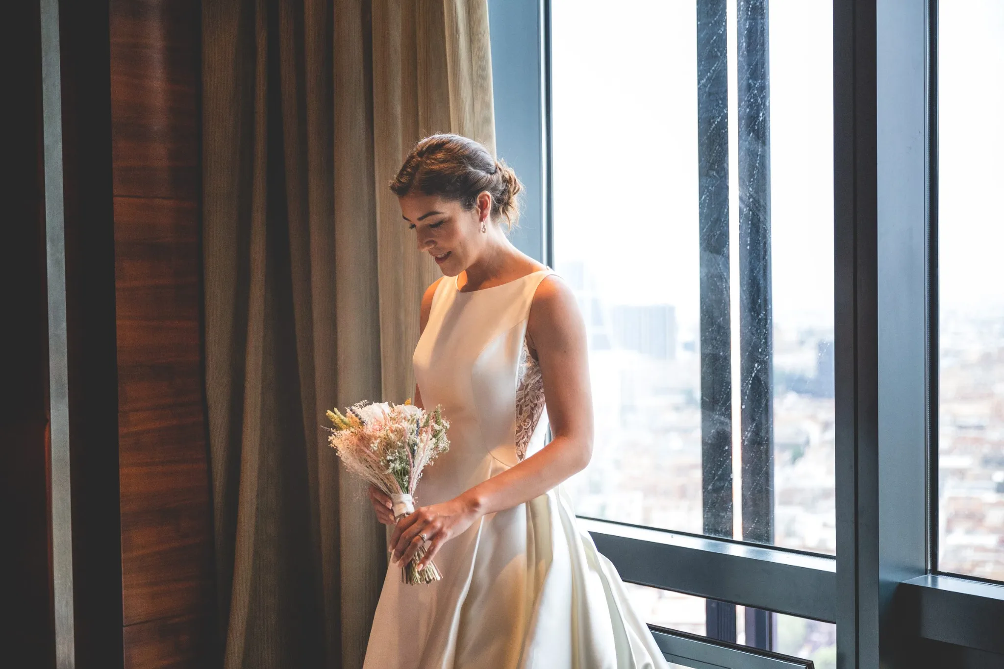 Novia junto a la ventana antes de salir durante una boda en Valquijancho.