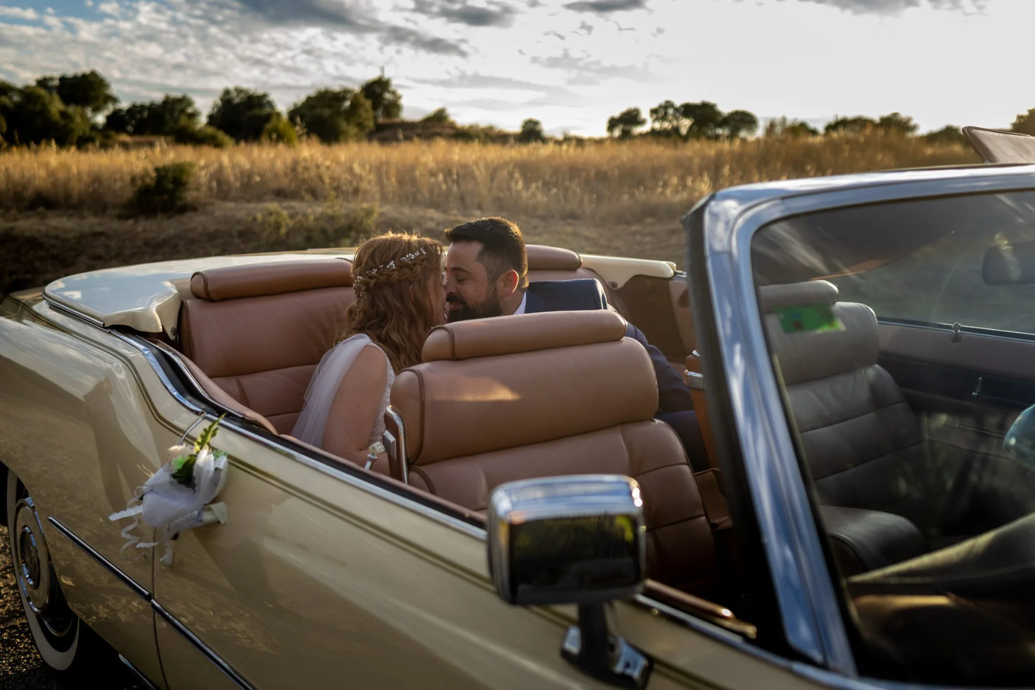 Novios besandose en coche descapotable durante una boda en Valquijancho.