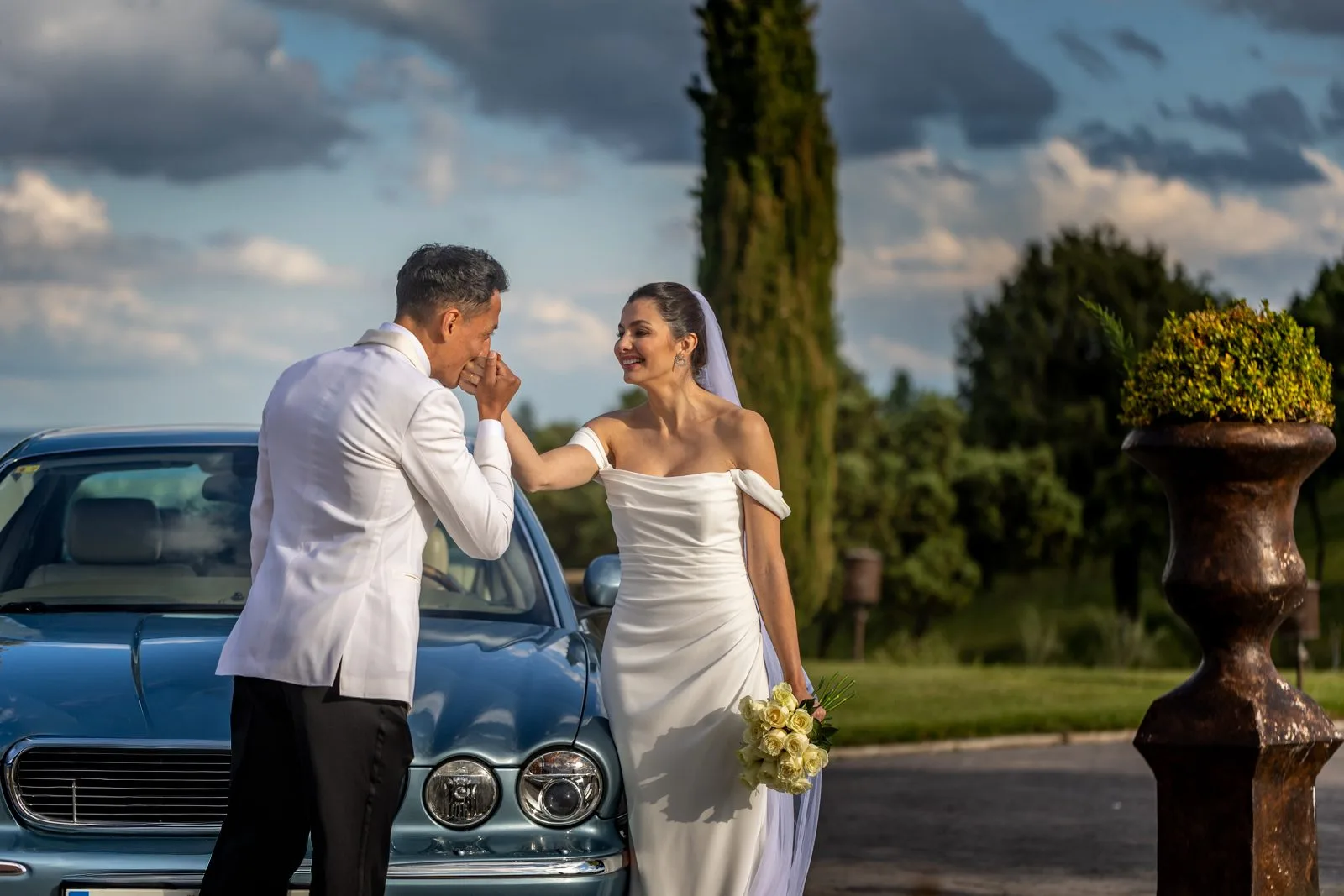Novios junto al coche azul durante una boda en Valquijancho.