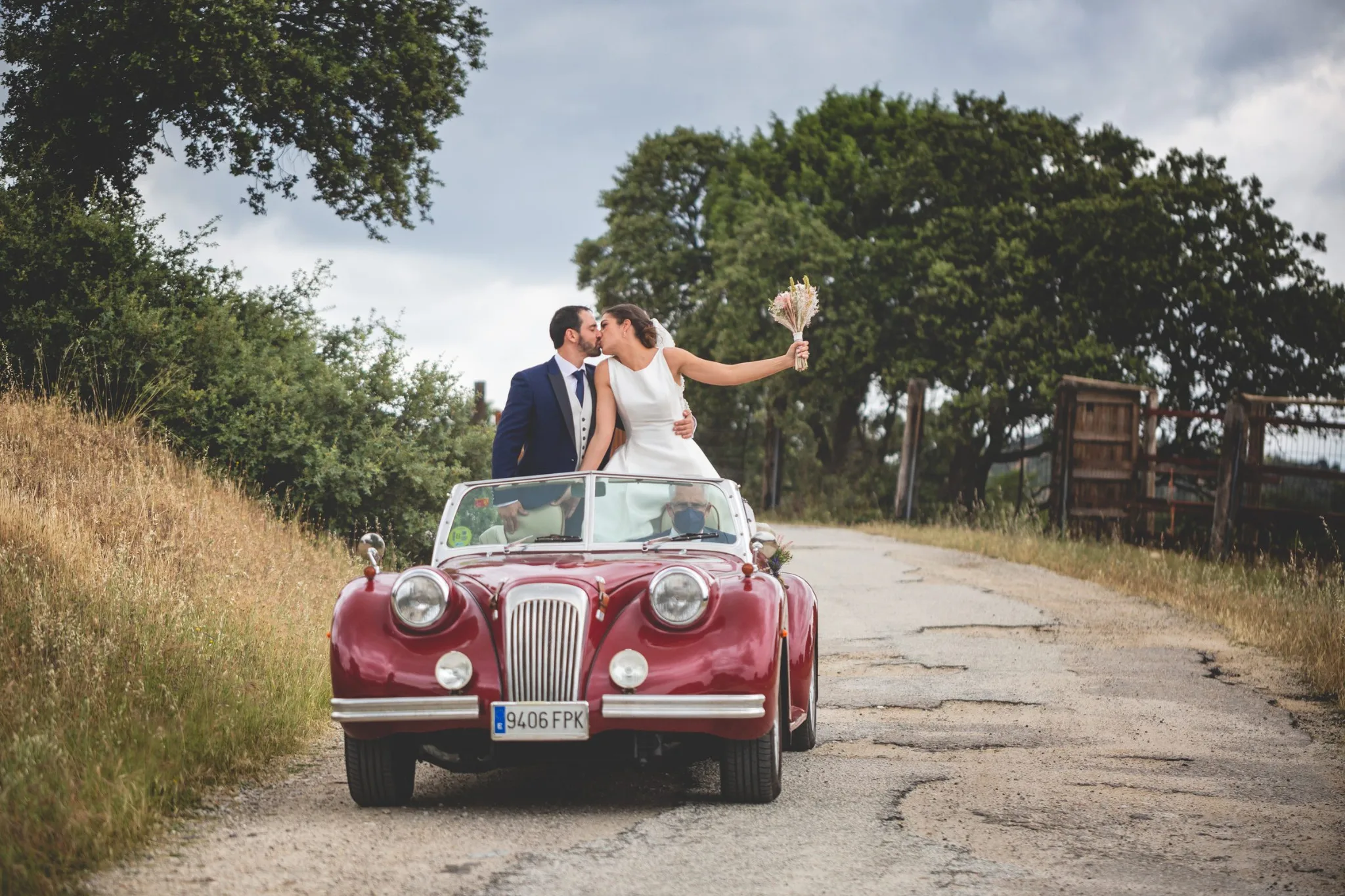Novios celebrando sobre coche clasico durante una boda en Valquijancho.