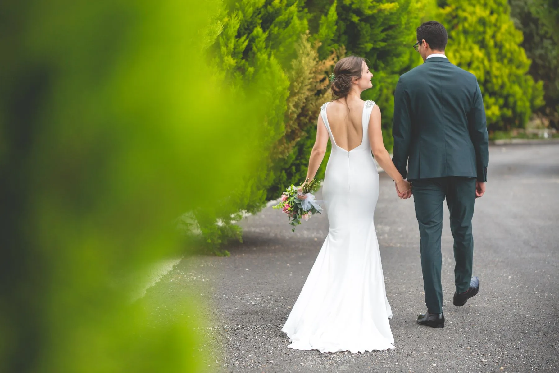 Novios caminando de espaldas por la finca durante una boda en Valquijancho.