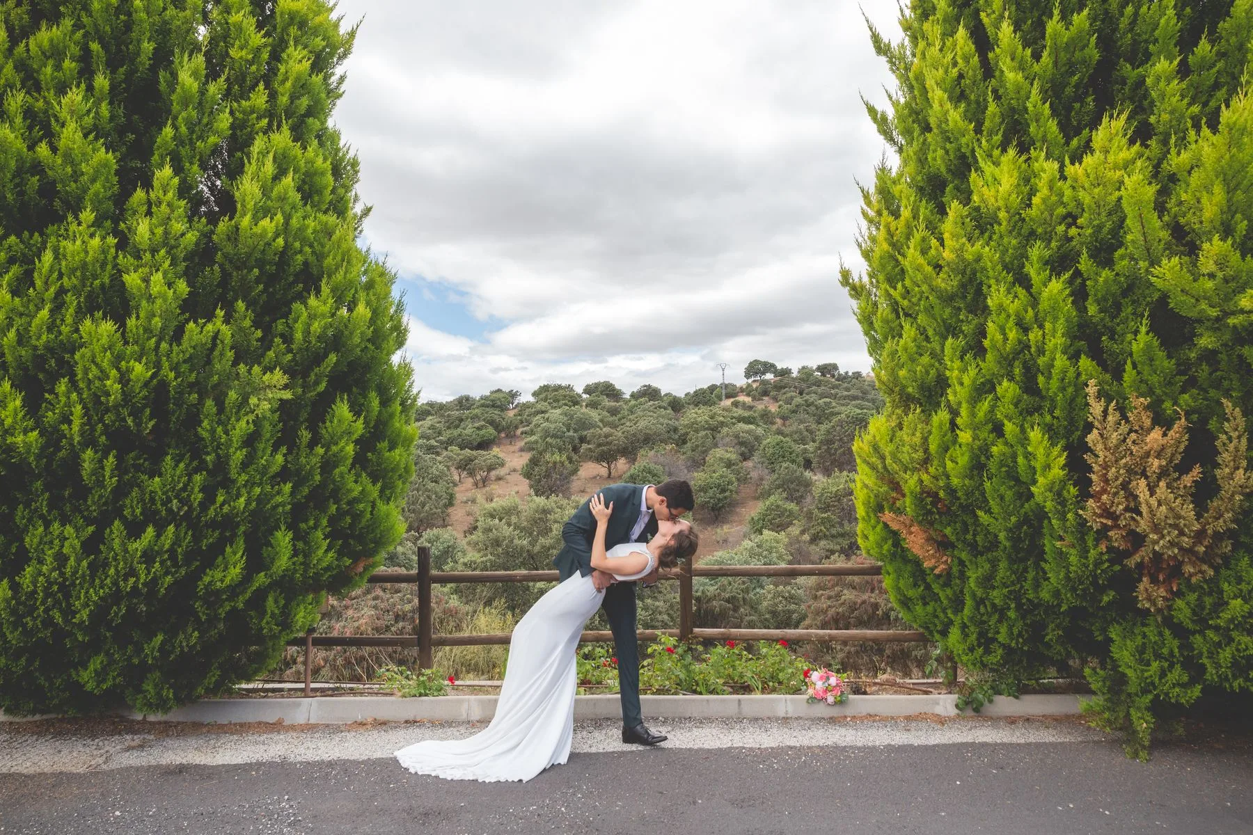 Beso de los novios junto a los cipreses durante una boda en Valquijancho.