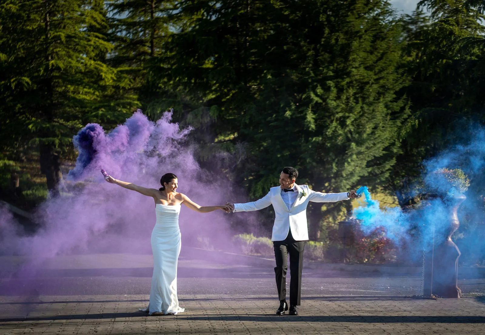 Novios con humo de colores en el exterior durante una boda en Valquijancho.