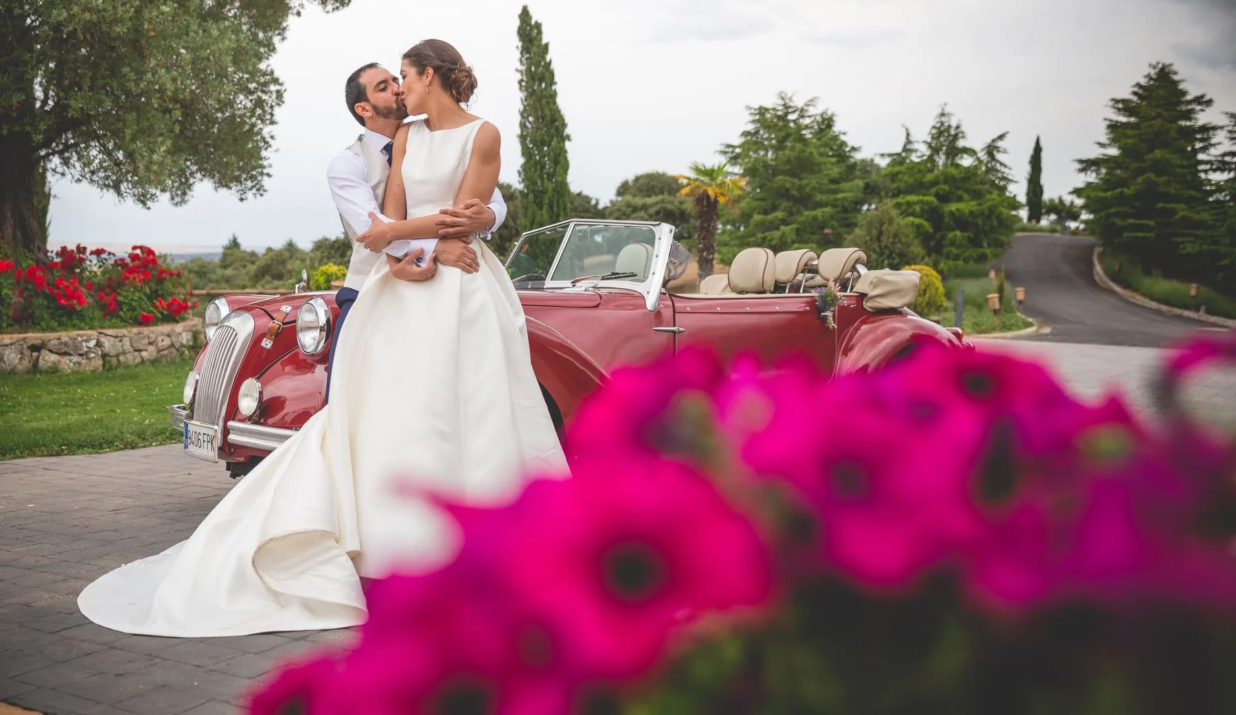 Novios junto al coche entre flores durante una boda en Valquijancho.