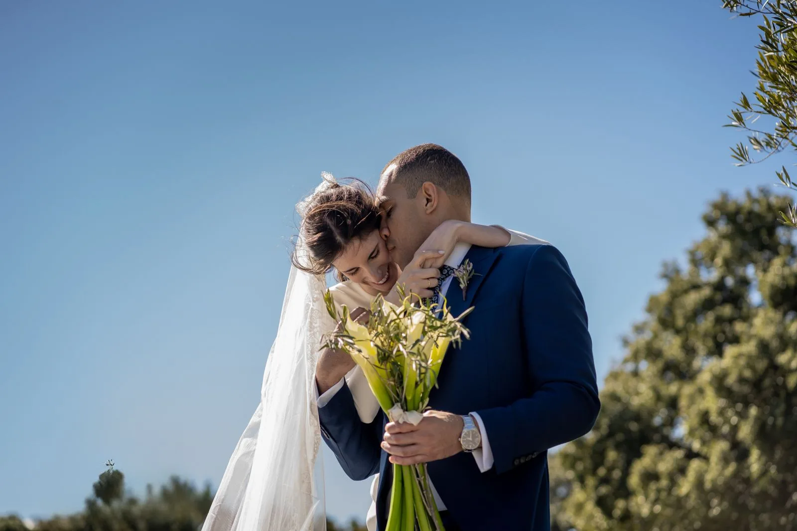 Beso de los novios con ramo durante una boda en Valquijancho.