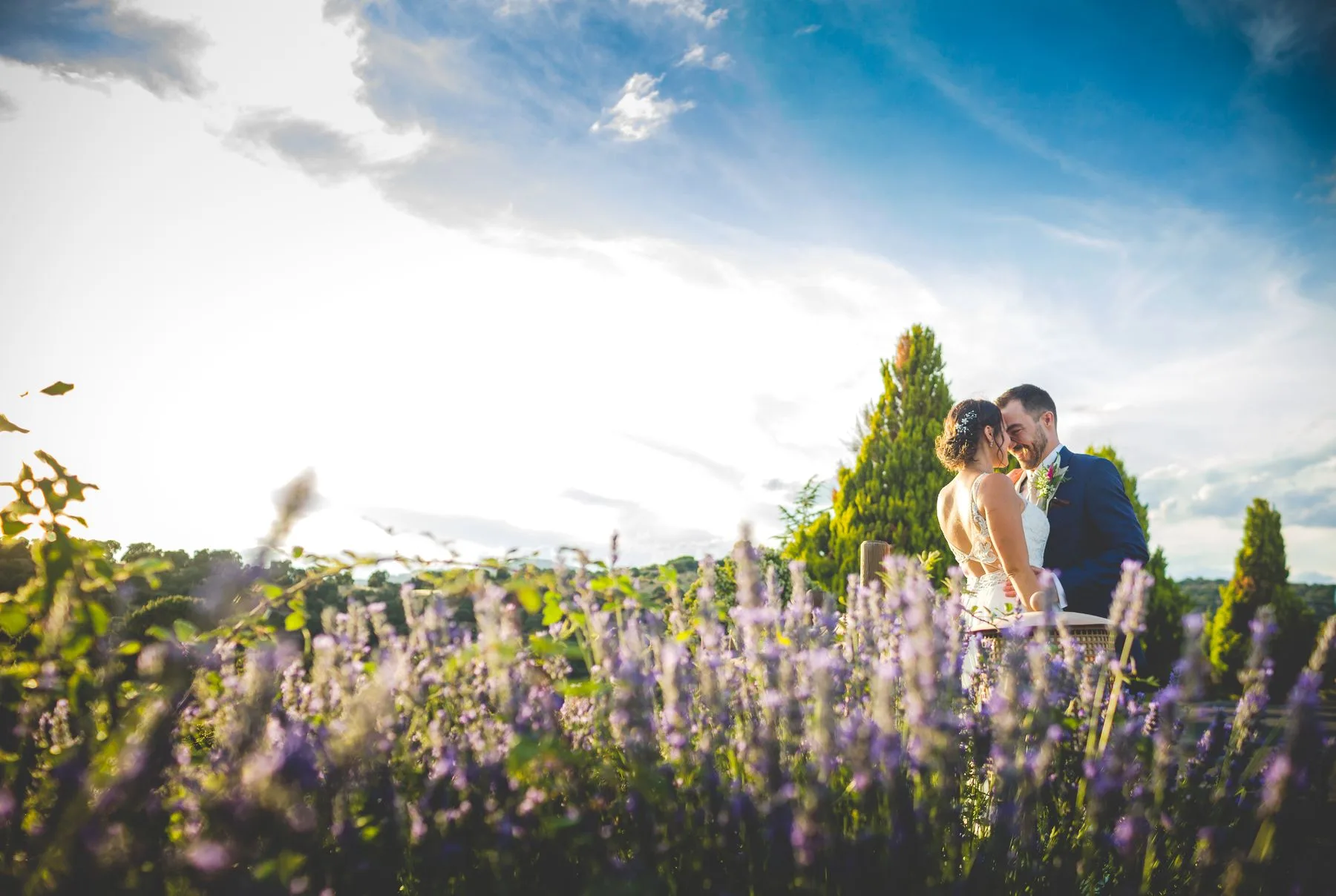 Novios entre lavandas y cielo azul durante una boda en Valquijancho.