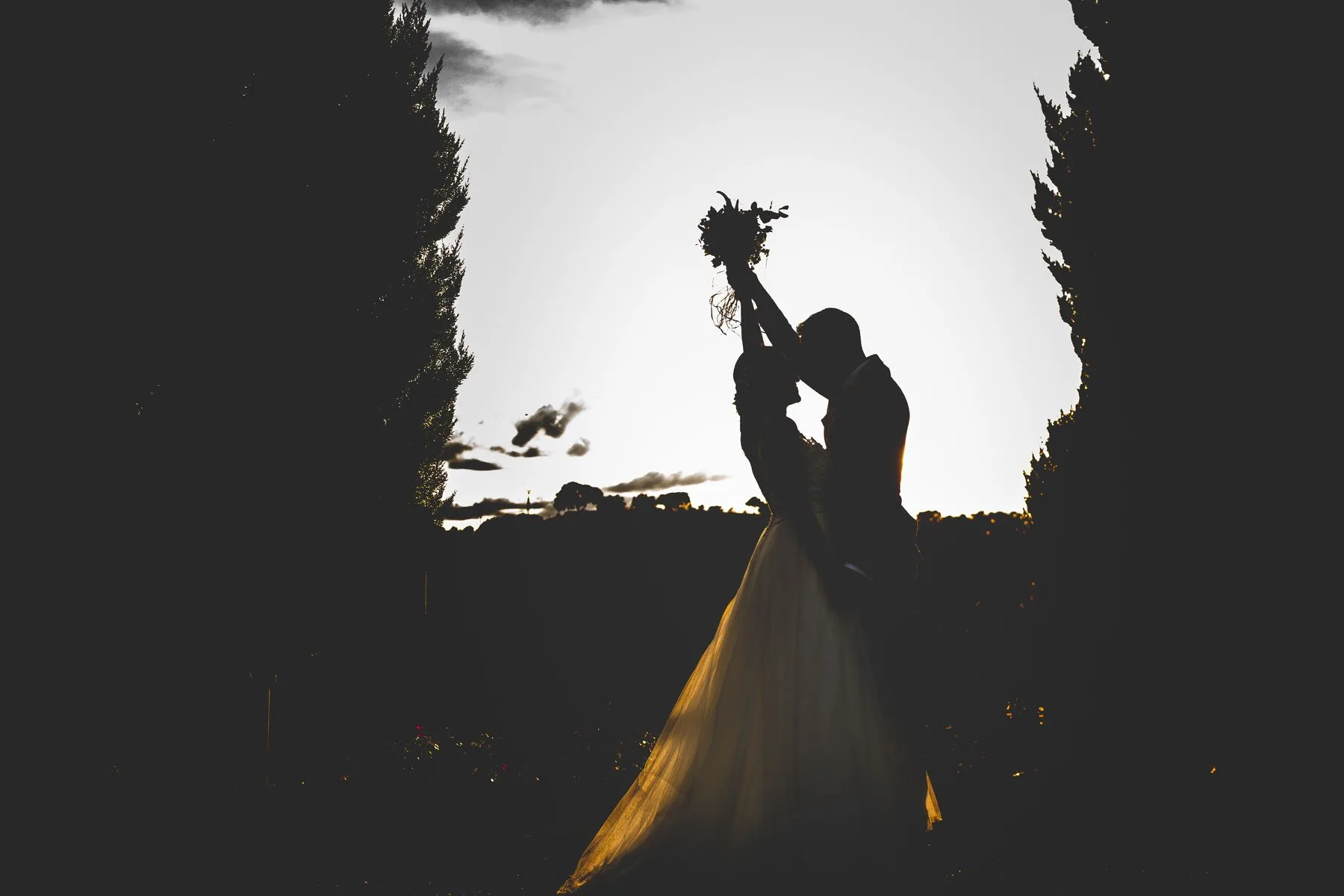 Silueta de novios entre cipreses durante una boda en Valquijancho.